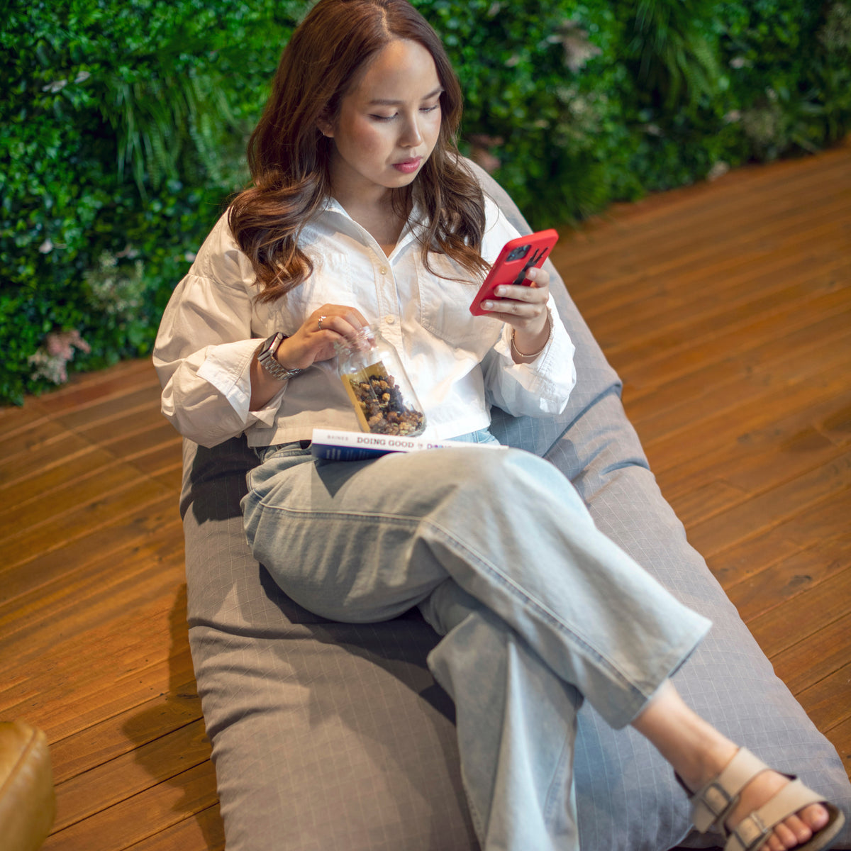 Woman on a bean bag looking at her phone