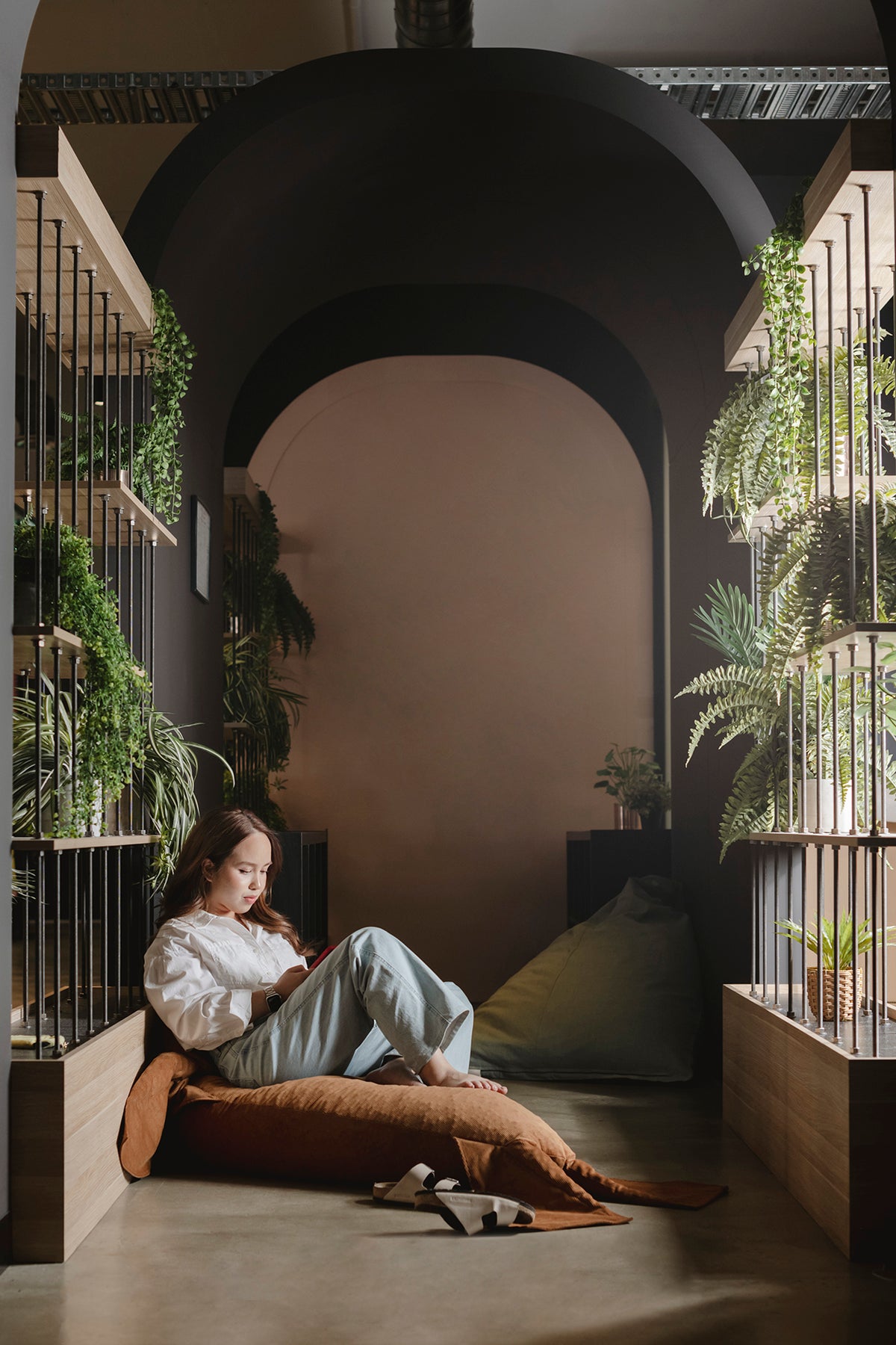 Woman reading on a brown bean bag in an arched alcove