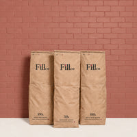 Fill Co Black paper bags, 50 L and 100 L, against a clay-red wall