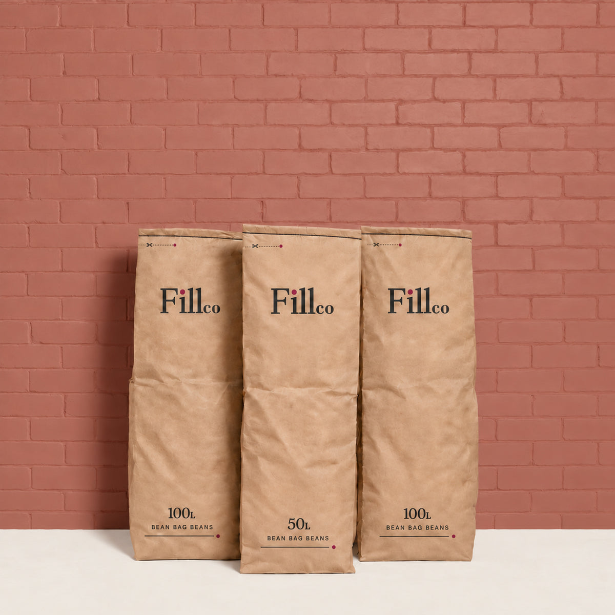 Fill Co Black paper bags, 50 L and 100 L, against a clay-red wall