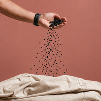 Pouring Fill Co Black beans from one hand into an oatmeal cover