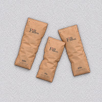 Three Fill Co paper bags lying on a bed of White beans