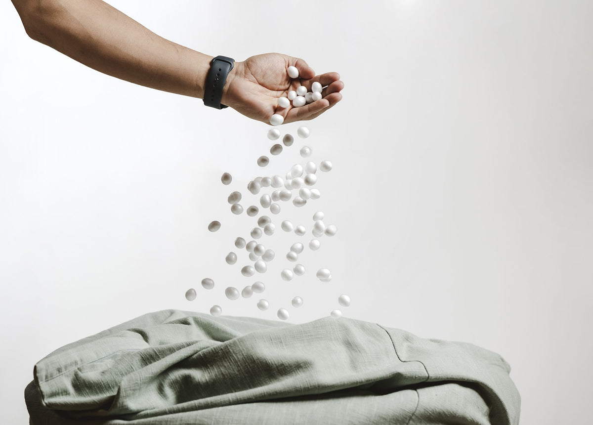Envee beans pouring from a hand into a green bean bag